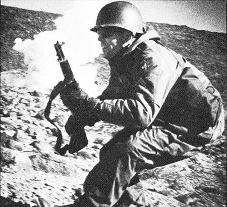 Cpl. Gerald Feathers of Waupaca’s Battery A, 2nd Howitzer Battalion, 120th Field Artillery reacts to the explosion of an artillery simulator during Exercise Bristle Cone at Fort Irwin, Calif. in March 1962. Photo courtesy of the 32nd Division Veterans Association
